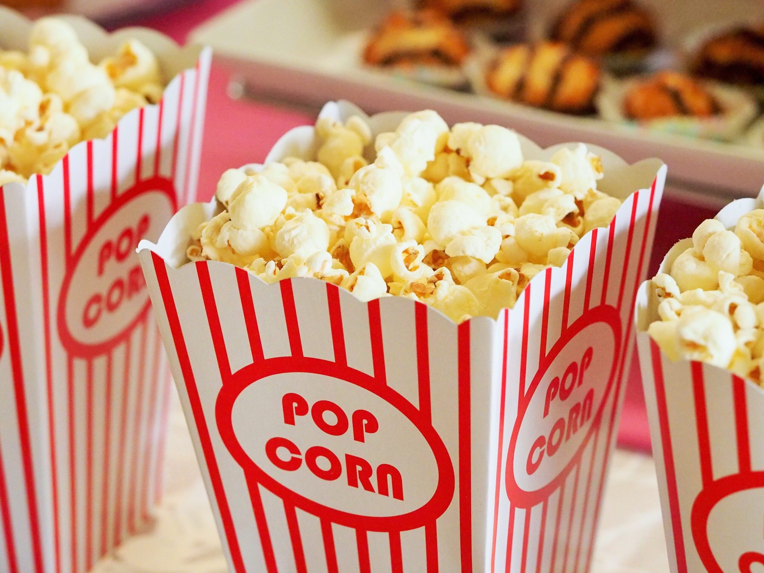 Red and white striped boxes filled with fluffy popcorn, ready for a movie night or a fun snack time.