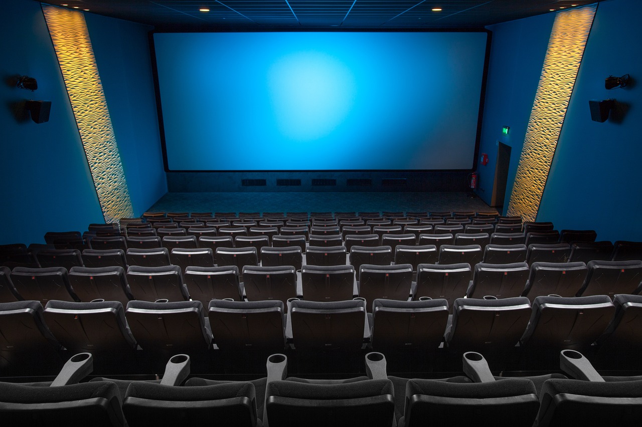 An empty theater featuring a large blue screen, highlighting the quiet and anticipation of an upcoming performance.